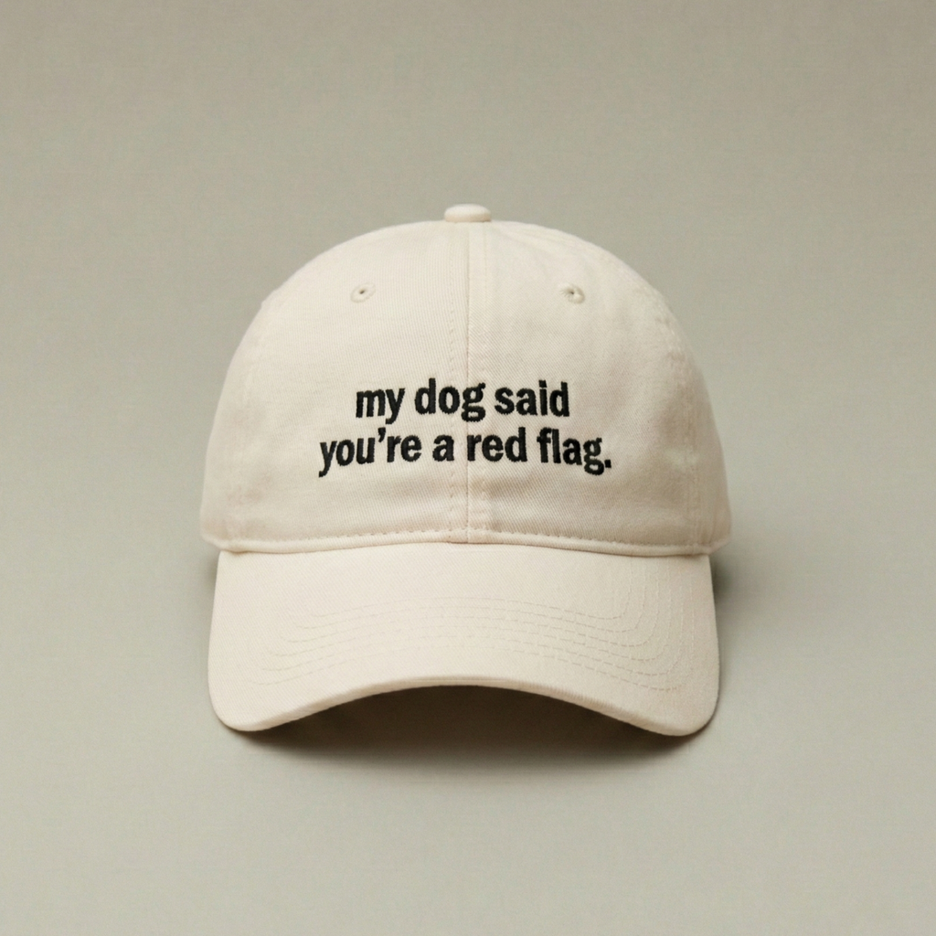 Snarky Barks 'my dog said you're a red flag.' cream embroidered dad hat, front view