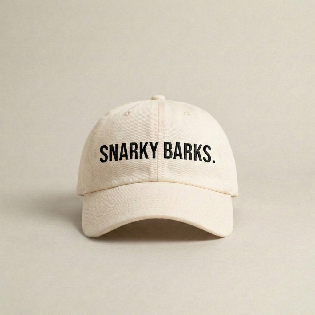 Snarky Barks logo cream embroidered dad hat with adjustable snap back, front view